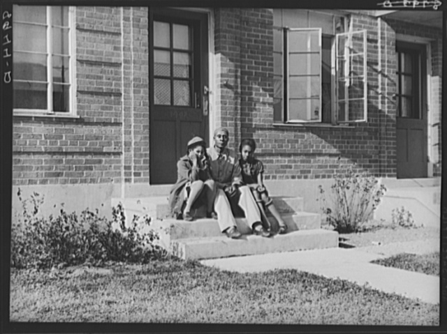A family seated on the steps of the Logan Fontenelle Housing Project in Omaha's Near North Side, 1938